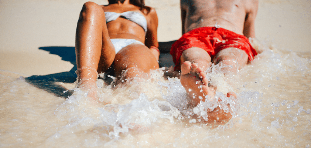 Женщина и мужчина загорают на пляже в солнечный день.